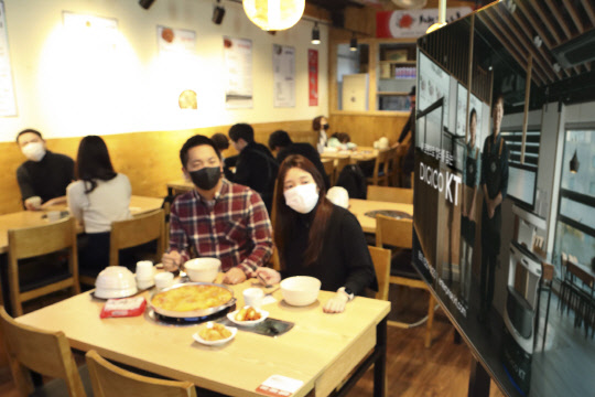 KT AI 서비스로봇 광고를 보고 있는 손님 모델. <KT 제공>